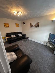 a living room with a couch and a television at Wessex Stays - Spacious 1 Bedroom Property in Willaston