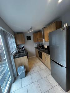a kitchen with a stainless steel refrigerator and wooden cabinets at Wessex Stays - Spacious 1 Bedroom Property in Willaston +9 photos