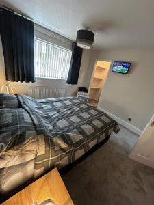a bedroom with a bed and a tv on the wall at Wessex Stays - Spacious 1 Bedroom Property in Willaston