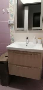 ein Badezimmer mit Waschbecken und Spiegel in der Unterkunft Dancing soul studio in Bukarest