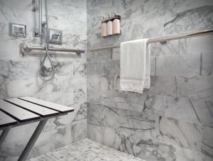 a bathroom with a marble shower with a bench at La Playa Beach & Golf Resort, a Noble House Resort in Naples
