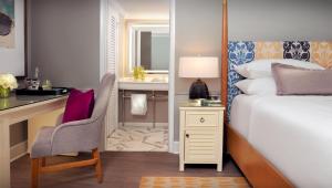 a bedroom with a bed and a desk and a desk at La Playa Beach & Golf Resort, a Noble House Resort in Naples