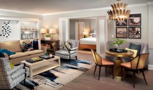 a living room with a couch and a room with a bed at La Playa Beach & Golf Resort, a Noble House Resort in Naples
