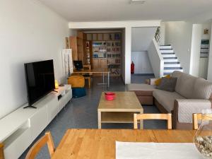 a living room with a couch and a tv at A casa da Xã in Almagreira