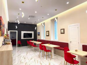 a dining room with tables and red chairs at AuRoom in Naples