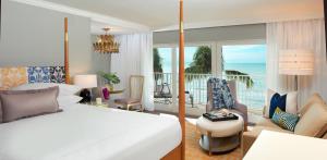 a bedroom with a bed and a balcony with the ocean at La Playa Beach & Golf Resort, a Noble House Resort in Naples