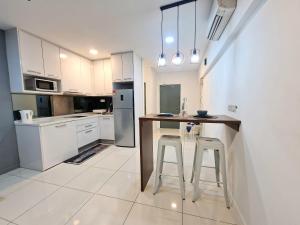 Summer Luxury Suites KlCC by ATIQ في كوالالمبور: مطبخ مع طاولة وكراسي فيه
