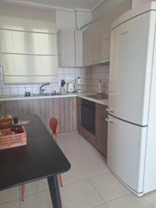 a kitchen with a white refrigerator and a table at Noma apartment in Gythio