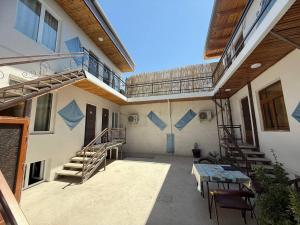 a balcony of a house with stairs and a table at Afsona guest house in Bukhara