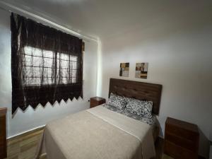 a bedroom with a bed and a window at Duplex a martil 2 min plage in Martil