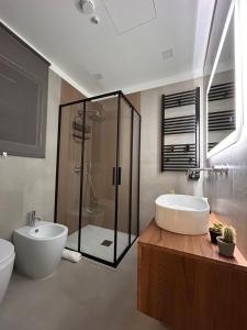 a bathroom with a tub and a sink and a shower at Sarò rooms in Pietraperzia