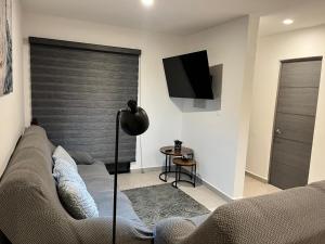 a living room with a couch and a flat screen tv at Residencia Santa Fe in San Rafael