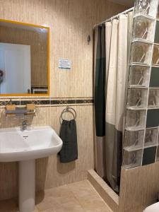 a bathroom with a sink and a shower curtain at The Bajondillo terrace in Torremolinos +37 photos