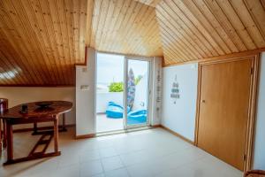 a room with a table and a sliding glass door at Neptune Beach House in Lourinhã
