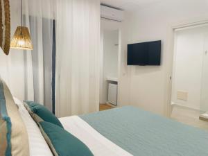 a bedroom with a bed and a flat screen tv at Elis rooms & suite in Olbia