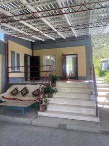 a house with stairs and a couch in front of it at Taldy-Bulak Guest House in Barskoon