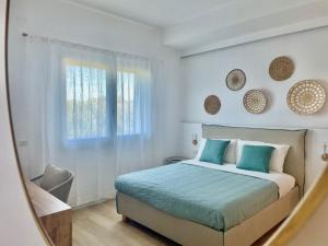 a bedroom with a bed with blue pillows and a window at Elis rooms & suite in Olbia