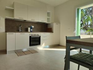 a kitchen with white cabinets and a table and a window at Soggiorno in villa - apt with kitchen and terrace in Gambellara
