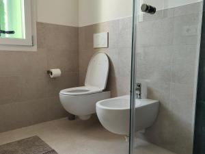 a bathroom with a toilet and a glass shower at Soggiorno in villa - apt with kitchen and terrace in Gambellara