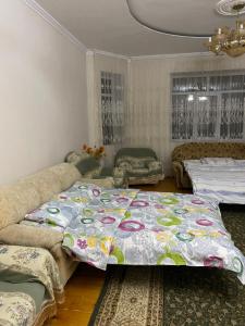 a living room with a large bed and a couch at Talas guest house in Talas