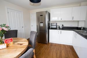 a kitchen with a wooden table and a stainless steel refrigerator at City and Loch Ness Blend in Inverness