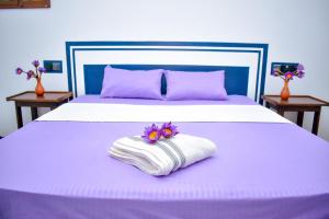 - un lit avec une serviette et des fleurs dans l'établissement Arcadiaa Hotel, 