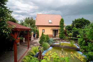 a house with a koi pond in a garden at Domek nad Oczkiem - Giżycko in Giżycko