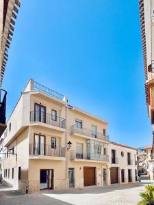 a white building with balconies on a street at Placeta Serna La Buena Vida in Vélez Rubio
