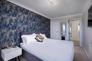 a bedroom with a white bed and a blue wall at The Beachcomber - seafront, free parking, free wifi in Cleveleys