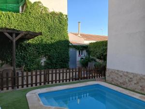 a swimming pool in a yard next to a fence at La Casa del Cerrillo in Sonseca