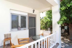 a porch with two chairs and a window at Η Μουριά, The Mouria House in Pefkochori