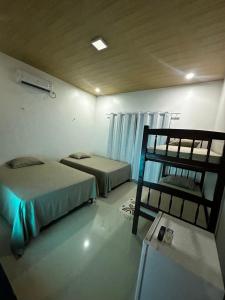 巴雷里尼亚斯Pousada Caju - Barreirinhas - Lençóis Maranhenses - Hotel的客房设有两张床和一张双层床。