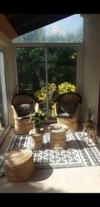 a patio with wicker chairs and plants on a rug at Villa Lina 6 pers plages et rivières in Prunelli-di-Fiumorbo