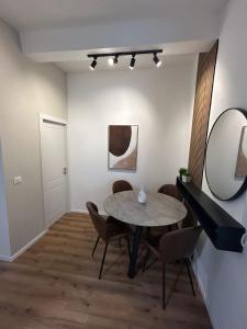 a dining room with a table and chairs and a mirror at Eden apartment in Haifa +19 photos