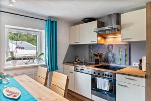 a kitchen with a table and a stove top oven at Ferienwohnung Montana Amor in Prutz