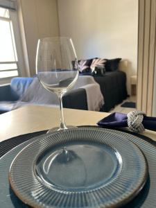 a wine glass and a plate on a table at Estúdio Silencioso e bem localizado Plano Piloto in Brasilia