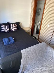 a bedroom with a bed and a bathroom with a sink at Estúdio Silencioso e bem localizado Plano Piloto in Brasilia
