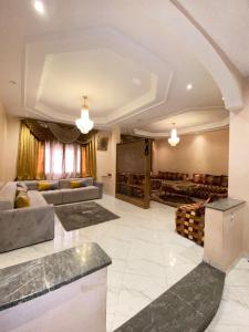 Una gran sala de estar con dos sofás y una pantalla. en Modern apartment, en Oujda