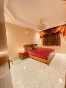 Un dormitorio con una cama roja y una ventana. en Modern apartment, en Oujda
