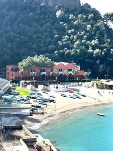 a beach with boats in the water next to a building at L'oblo' sul mare Sorrento Coast in Vico Equense