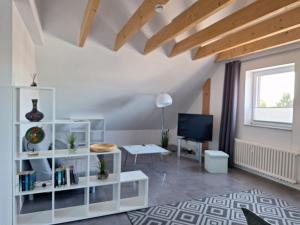 a living room with a white book shelf and a tv at Moderne Wohnung in Krefeld in Krefeld