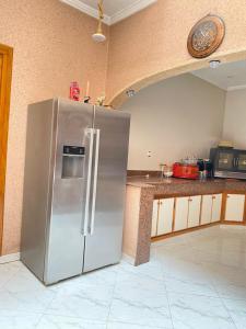 a stainless steel refrigerator in a kitchen at Modern apartment in Oujda +9 photos