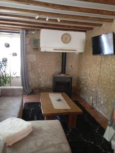 a living room with a couch and a table and a clock at La chaise in Saint-Aquilin