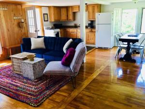 a living room with a blue couch and a table at Sunny & Open 2 Bdrm - Close to Stowe Village, Shopping, Mtn Views! in Stowe