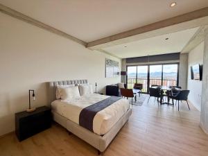 a bedroom with a large bed and a dining room at Second Home Juárez 56 in Mexico City