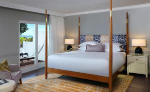 a bedroom with a large bed and a balcony at La Playa Beach & Golf Resort, a Noble House Resort in Naples