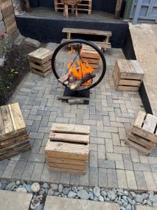 a fire pit with logs and a table and a bench at Serengeti Home in Arusha