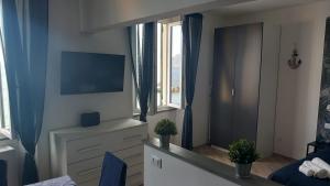 a living room with a tv and a window at Due Finestre Sul Mare in Bogliasco