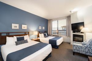 a hotel room with two beds and a television at Ocean Promenade Hotel in White Rock