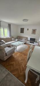 a living room with couches and a table at Olive Roots Yard House in Trebinje